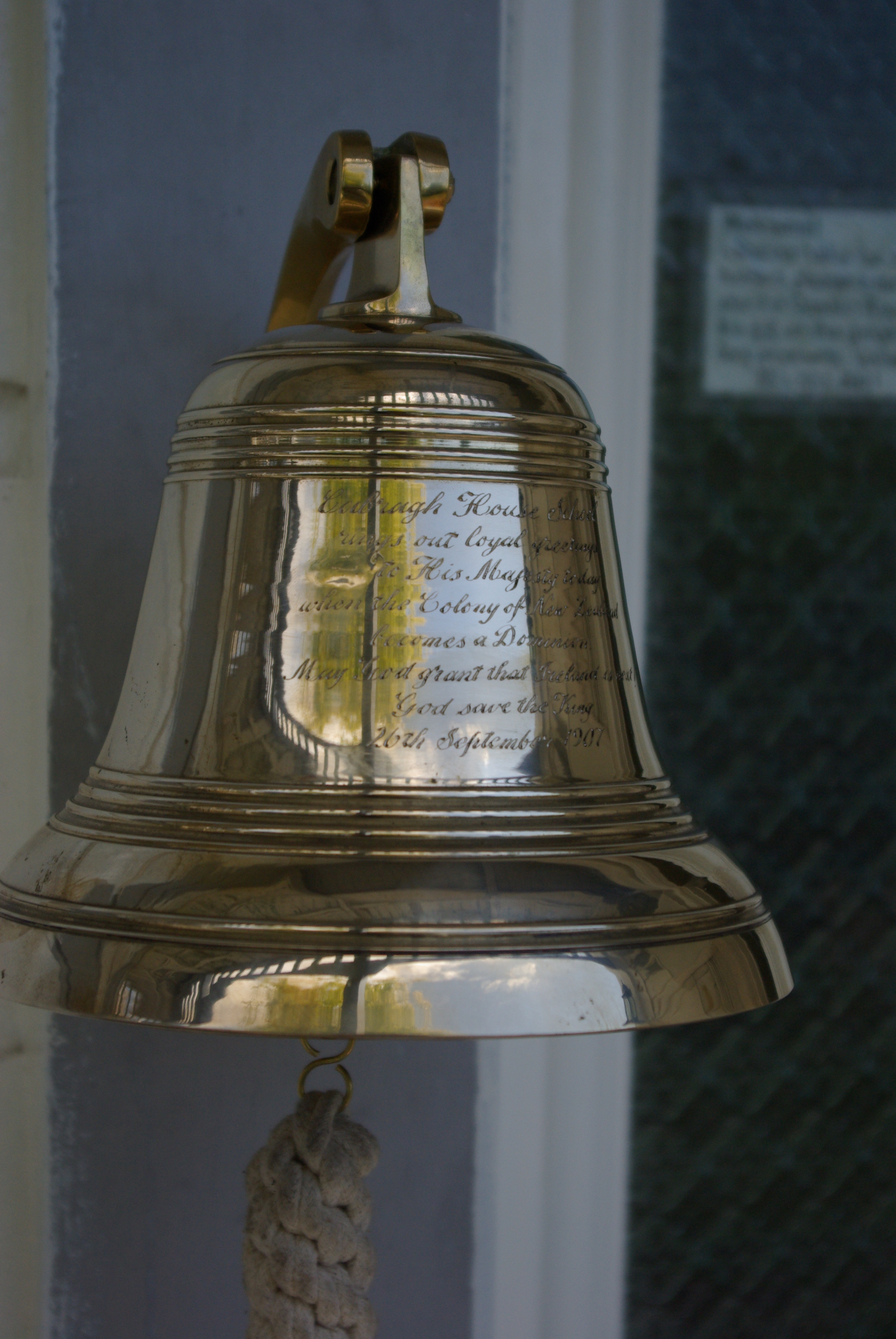The 1907 brass bell from Cabragh House School that hangs at the door of Amber House Bed and Breakfast in the Nelson-Tasman region of the South Island of New Zealand